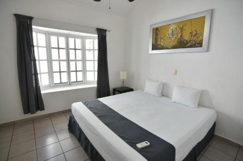sypialnia z dużym łóżkiem i oknem w obiekcie Tulipanes Cancun w mieście Cancún