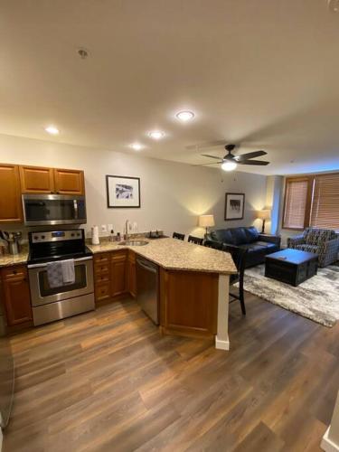 a kitchen and living room with a stove and a couch at Ski-In/Ski-Out Zephyr 1 Bedroom Condo Winter Park in Winter Park