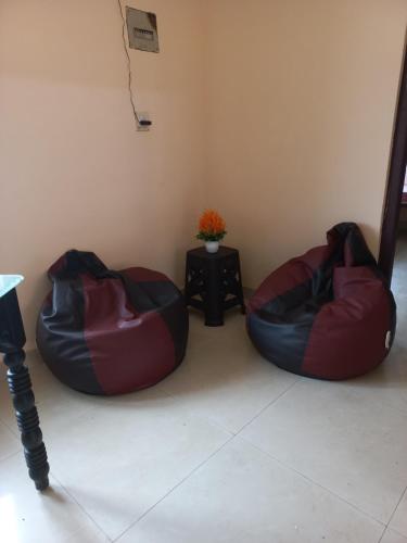 2 pufs en una habitación con mesa en Beyond Home en Kozhikode