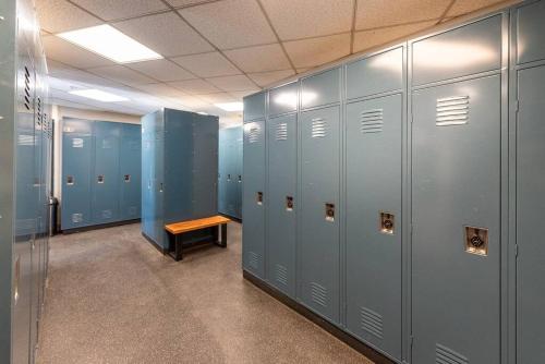 a locker room with blue lockers and a wooden bench at Ski-In/Ski-Out Zephyr 1 Bedroom Condo Winter Park in Winter Park