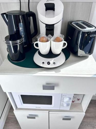 une cafetière et deux tasses sur un comptoir dans l'établissement Le petit midi - Parking - Métro - Fibre - Canal, à Toulouse