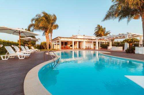 ポリニャーノ・ア・マーレにあるVilla Volareの椅子と家のあるプール