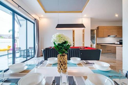 a dining room table with a vase of flowers on it at Villa Me&you 3 in Ban Bo Fai (1)