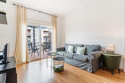 a living room with a couch and a table at Fridays Flats Heart Of The City Sunny With Iconic Terrace View in Barcelona