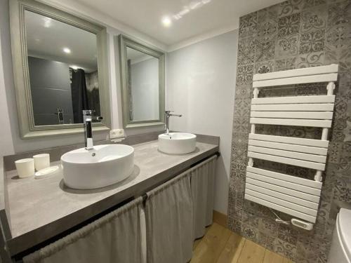 a bathroom with two sinks and a large mirror at Au Grand Duc in Cauterets