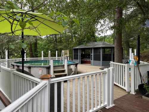 a deck with a white fence and a gazebo at 3 Acre Lake Paradise Swimming Pool & Jacuzzi HotTub! in Hopatcong