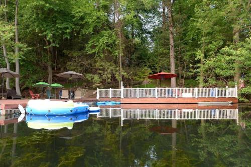 a dock with three boats in the water at 3 Acre Lake Paradise Swimming Pool & Jacuzzi HotTub! in Hopatcong