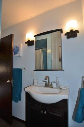 a bathroom with a sink and a mirror at 3 Acre Lake Paradise Swimming Pool & Jacuzzi HotTub! in Hopatcong