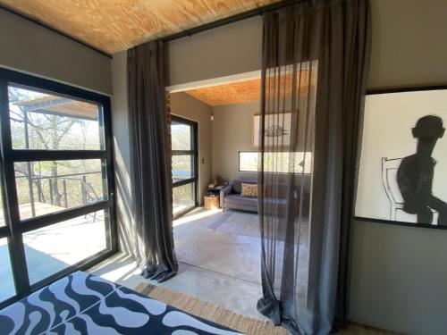 a bedroom with a bed and a large window at Terrapin Studio in Marloth Park