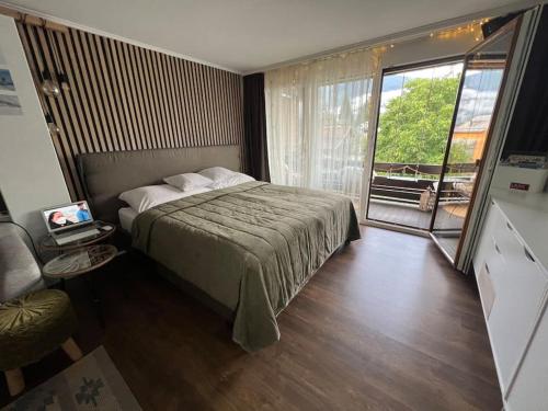 a bedroom with a bed and a large window at Jollie‘s in Laax