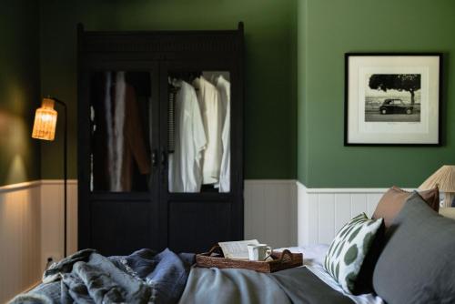 a bedroom with green walls and a black door at Taylor's of Berry in Berry