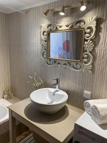 a bathroom with a sink and a mirror on the wall at Villa Harmony in Kría Vrísi
