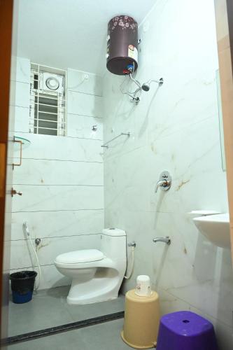 a white bathroom with a toilet and a sink at KK SERVICE APARTMENTS in Vellore