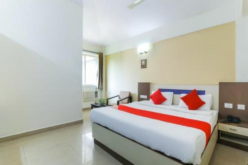 a bedroom with a large bed with red pillows at Hotel City Garden in Madgaon