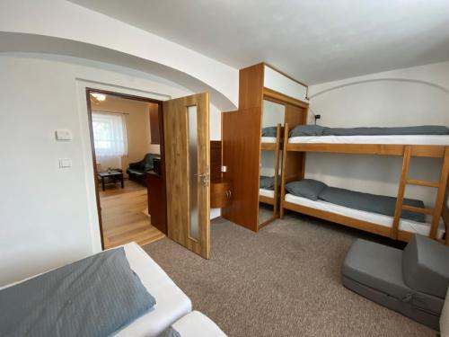 een slaapkamer met 2 stapelbedden en een woonkamer bij Penzion Mořina in Mořina