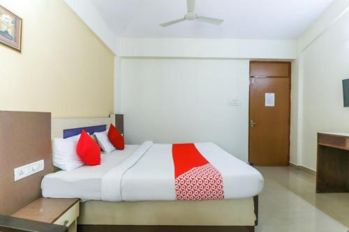 a bedroom with a large bed with red pillows at Hotel City Garden in Madgaon