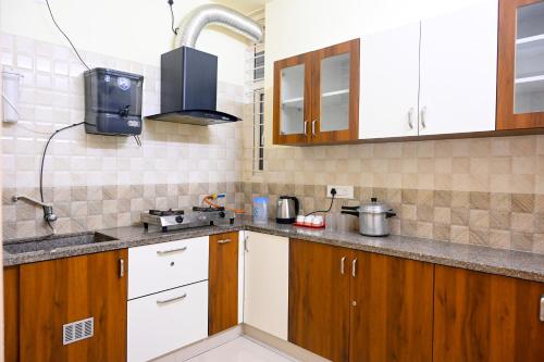 a small kitchen with wooden cabinets and a sink at KK SERVICE APARTMENTS in Vellore