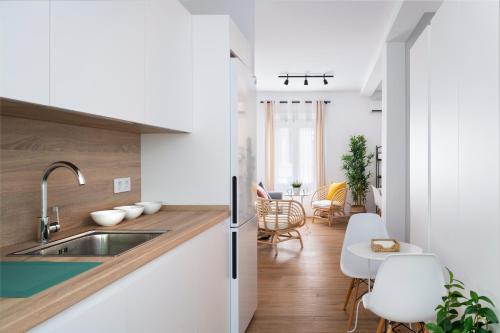 a kitchen with a sink and a table with chairs at Magno Apartments Miño in Seville