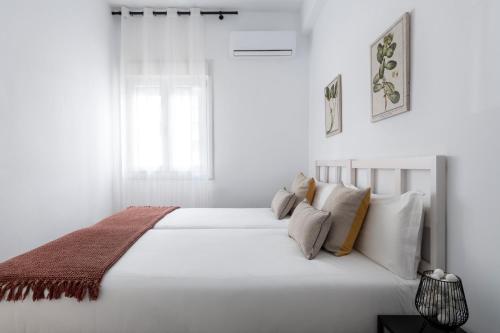 セビリアにあるMagno Apartments Miñoの白いベッドルーム(枕付きの大きな白いベッド付)
