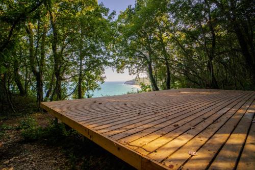 a wooden deck with a view of the ocean at Къщички Синьо лято, Черноморец - Варна - Blue Summer Houses Varna in Varna City