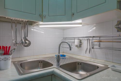uma cozinha com dois lavatórios e armários azuis em Bomboniera di Cisternino em Cisternino