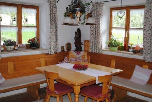 a dining room with a table and chairs and windows at Braun Hof in Fischbachau