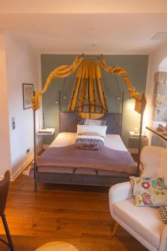 a bedroom with a canopy bed and a couch at Holzwerk Oybin in Kurort Oybin