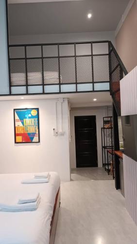 a bedroom with a bed and a staircase in a room at Jeboutiquelangsuan hotel in Lang Suan