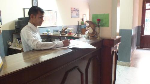 a man sitting at a counter in a kitchen at Hotel Dolphin in Kathmandu