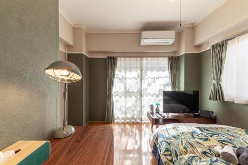 um quarto com uma cama, uma secretária e uma televisão em FUJITAKI CORP em Tóquio
