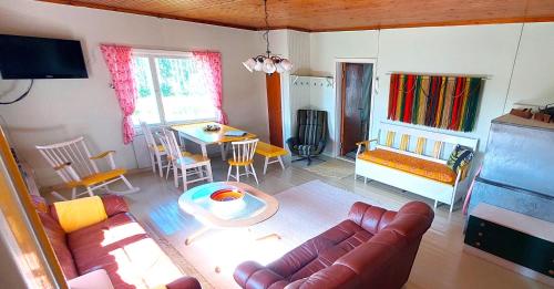 ein Wohnzimmer mit einem Sofa und einem Tisch in der Unterkunft Villa Mummola Kahden makuuhuoneen huoneisto lähellä jokea in Simpele