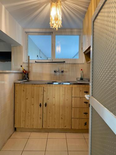 a kitchen with wooden cabinets and a window at Studio Cleopatra in Kanali