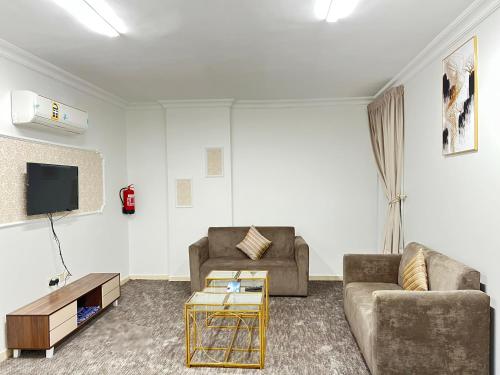 - un salon avec deux canapés et une télévision dans l'établissement غزالي للوحدات السكنية, à Médine