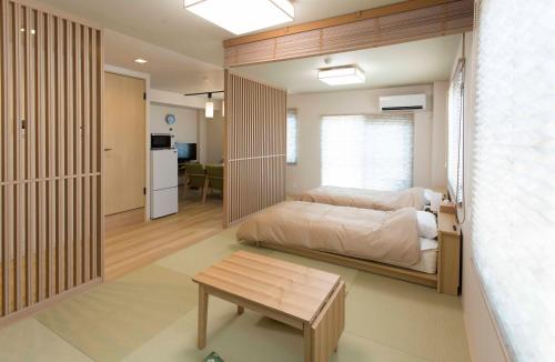 een slaapkamer met een bed en een tafel in een kamer bij PAL-TERRACE FUJIMI in Tokyo