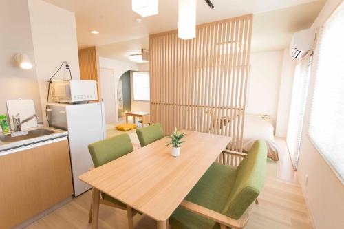cocina y comedor con mesa de madera y sillas en PAL-TERRACE FUJIMI, en Tokio