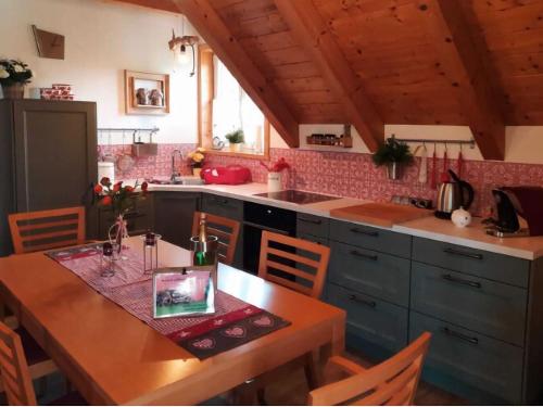 cocina con mesa de madera, mesa y sillas en Holiday apartment near Lake Klopeiner with sauna, en Neuhaus