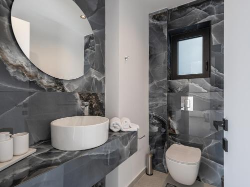 a bathroom with a sink and a mirror at Avrilia Seaside Villa HEATED POOL in Almyrida