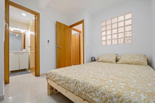 a bedroom with a bed and a door to a bathroom at Little Horse in Tarragona
