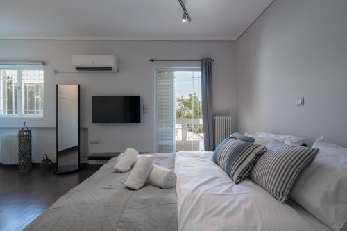 a white bedroom with a large bed with pillows at Seaside 2 Bedrooms Apartment in Glyfada in Athens