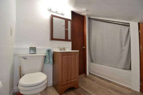 a bathroom with a toilet and a sink and a tub at Cozy Alcove Studio Apt w Outdoor deck w NYC Views in Jersey City