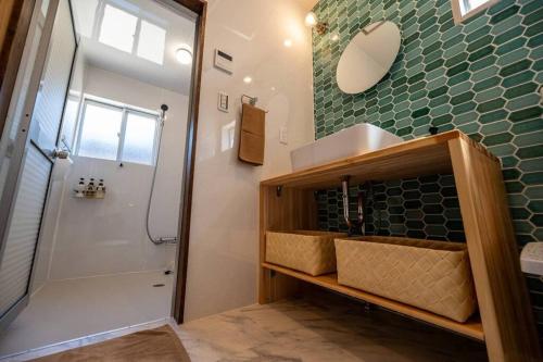 a bathroom with a shower and a sink and a mirror at 日向サーフキャンプ111 in Hyuga