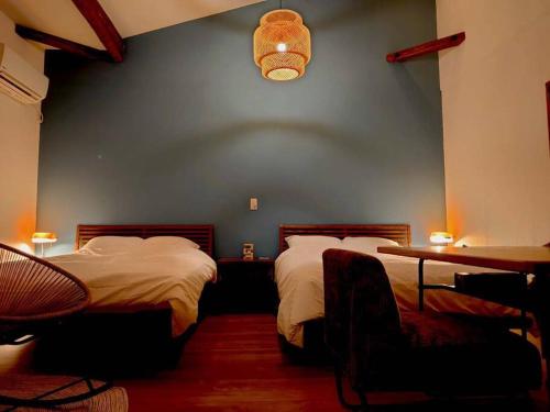 a bedroom with two beds and a blue wall at 日向サーフキャンプ111 in Hyuga
