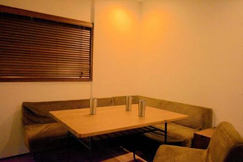 a living room with a table and a couch at 日向サーフキャンプ111 in Hyuga