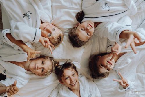 a group of children laying in a circle on a bed at Norweska Dolina Family&Pet-friendly Resort in Szklarska Poręba