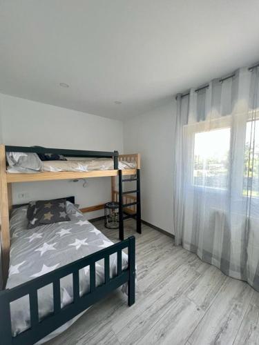 a bedroom with a bunk bed and a window at Villa Nela Loredo in Loredo