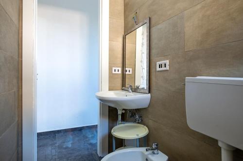 a bathroom with a sink and a toilet and a mirror at Appartamento Acquadolce n 2 in Torre Ovo