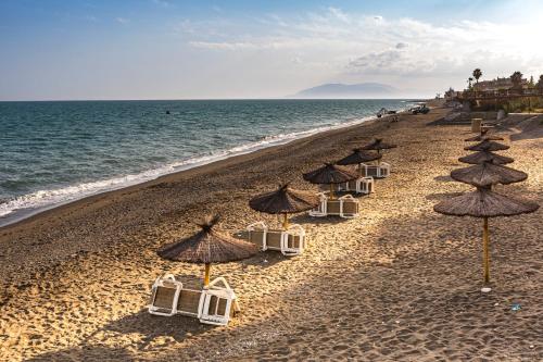 a group of chairs and umbrellas on a beach at Brisa del mar in Chilches