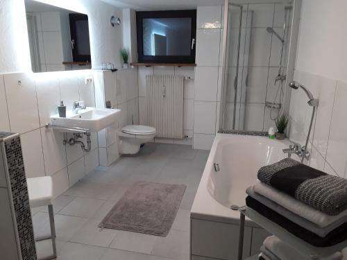 a bathroom with a tub and a toilet and a sink at Ferienwohnung Bieniussa 3 in Gemünden