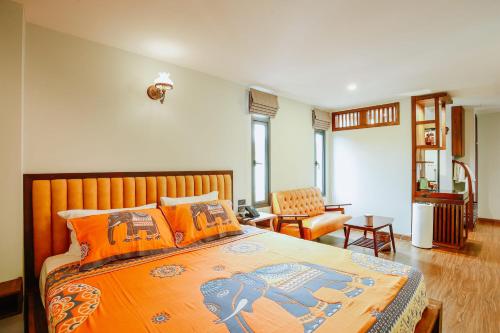 1 dormitorio con 1 cama grande con almohadas de color naranja en WangChang Hotel Chiang Mai โรงแรมวังช้าง เชียงใหม่ en Chiang Mai