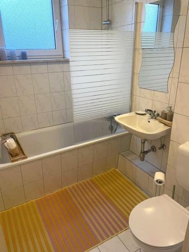La salle de bains est pourvue d'un lavabo, de toilettes et d'une baignoire. dans l'établissement Messe - Augsburg - Zentrum - 2 Zimmer - 3 Personen, à Augsbourg